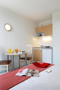 a bedroom with a bed with a book on it at Vacancéole - Les Demeures Champenoises in Épernay