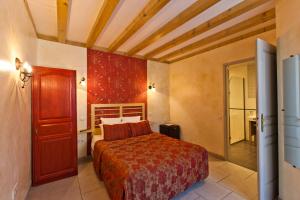 um quarto com uma cama grande num quarto em Hotel-restaurant Les Caudalies em Arbois