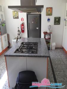 a kitchen with a stove and a refrigerator at Hostal Magnolio in Viña del Mar