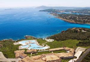 una vista aérea de un complejo y del océano en COLONNA RESORT, a Colonna Luxury Beach Hotel, Porto Cervo, en Porto Cervo