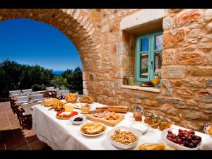 a table with food on it in front of a stone building at Arapakis Historic Castle in Pirgos Dhirou