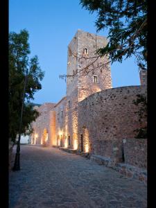 a large castle is lit up at night at Arapakis Historic Castle in Pirgos Dhirou