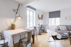 uma sala de estar com uma mesa e um sofá em Reflets Sur La Lauch appartements em Colmar