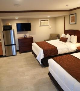 a hotel room with two beds and a flat screen tv at Beachside Resort in Wildwood