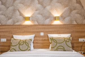 a bedroom with a bed with two pillows and two lights at Hotel Fevery in Bruges