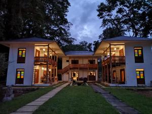 a large white house with a yard at Lanna Ban Hotel in Puerto Viejo