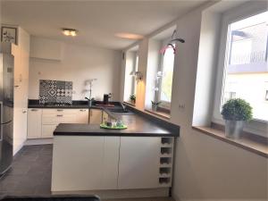 a kitchen with white cabinets and a black counter top at chambre d'hôte-abc in Reims