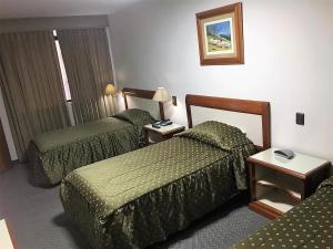 Cette chambre comprend 2 lits et une table. dans l'établissement Gran Hotel Continental, à Cajamarca