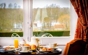 a table with plates of food and a window at Château De Pray in Amboise