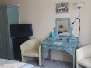 een slaapkamer met een blauw bureau met een spiegel en een bed bij Landhotel Ostseetraum & Fewo in Warnemünde