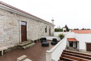 un patio con 2 sillas negras y un edificio en RURAL HOUSE, en Guifões