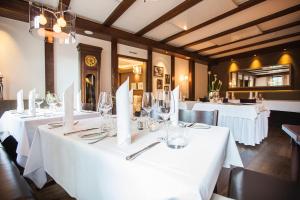 uma sala de jantar com mesas e toalhas de mesa brancas em Hotel Waldhorn em Böblingen