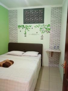 een slaapkamer met een bed en een foto aan de muur bij nDalem Eyang Dwijo in Yogyakarta