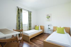 Kleines Zimmer mit 2 Betten und einem Tisch in der Unterkunft Pension Rosenhof in Linz