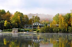 a house sitting on the shore of a lake at Le Boisé du Lac in Mont-Tremblant