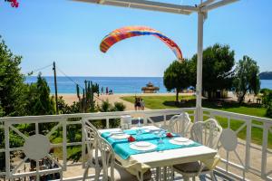 d'une table et de chaises sur un balcon avec parapente dans l'établissement Seyir Beach Hotel, à Ölüdeniz