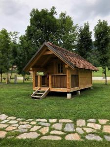 a small house with a porch on a field of grass at Camp Podgrad Vransko in Vransko