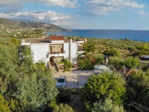 una vista aérea de una casa con el océano en el fondo en Paradeisos, en Kardhamili