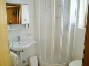 y baño blanco con lavabo y ducha. en Garni Sonnleiten, en Tirolo