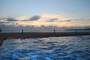 a swimming pool next to a beach with the ocean at AMAZING BEACH FRONT - ACQUA NUEVO VALLARTA - MX in Nuevo Vallarta 