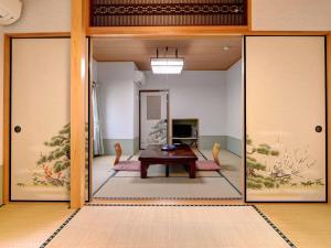 un soggiorno con tavolo e porta a vetri di Ryokan Niko a Koganei