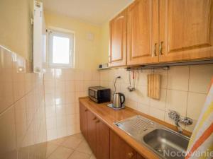 a small kitchen with a sink and a microwave at Dom Wczasowy Grażyna in Władysławowo