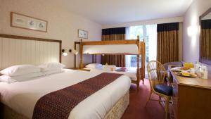 a hotel room with a large bed and a desk and a desk at Marwell Hotel - A Bespoke Hotel in Winchester