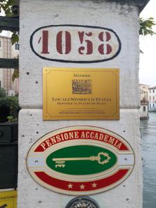 um sinal para um pizzeriaaccoaggle num poste em Pensione Accademia - Villa Maravege em Veneza