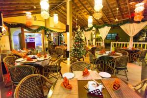 um restaurante com uma árvore de Natal e mesas e cadeiras em Shivers Oasis Luxury Boutique Resort em Candolim