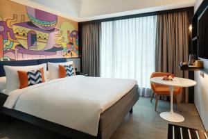 una habitación de hotel con una cama grande y una mesa en ibis Styles Jakarta Tanah Abang, en Yakarta