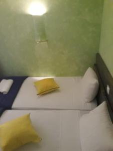 een slaapkamer met een bed met gele kussens en een lamp bij Vivenda Viviani in Praia