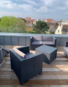 un patio avec des canapés et des tables sur le toit dans l'établissement VILLA "Le LOFT", à Wimereux