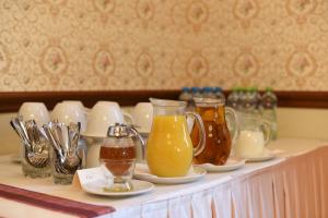 a table with cups and pitchers of drinks on it at Villa Žerotín Penzion Bed & Breakfast in Velké Losiny