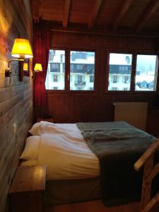 una camera con un letto in una stanza con finestre di Hôtel Vallée Blanche a Chamonix-Mont-Blanc