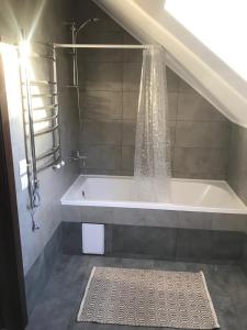 La salle de bains est pourvue d'une baignoire et d'une douche. dans l'établissement Green Energy Apartment, à Berehove