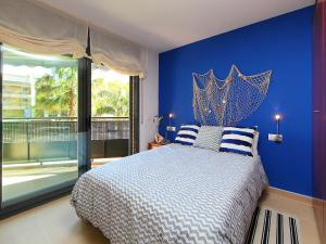 ein blaues Schlafzimmer mit einem Bett mit blauer Wand in der Unterkunft Apartment Can Pavet by Interhome in Vilafortuny