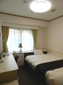 Giường trong phòng chung tại Check In Matsuyama