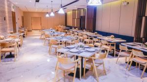 a row of tables and chairs in a dining room at Paco Hotel Tiyuxilu Metro Guangzhou-Free Shuttle Bus for Canton Fair in Guangzhou