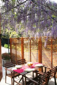 uma mesa de piquenique com cadeiras e uma coroa de flores roxas em Villa dei Fiori em Luino