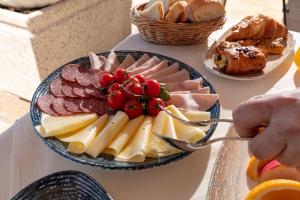 une assiette de fromage et de viande sur une table dans l'établissement Apartments Amigos, à Podstrana