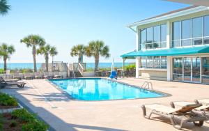 una piscina con sillas y un edificio en Oceanfront Litchfield Inn, en Pawleys Island