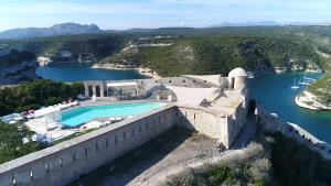 une piscine sur le côté d'un mur à côté d'une rivière dans l'établissement Hotel Spa Genovese, à Bonifacio