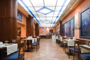 a dining room with tables and chairs and a ceiling at Hotel La Pace in Pisa