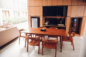 a dining room with a wooden table and chairs at Agranusa Signature Villa Nusa Dua in Nusa Dua