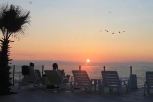 - un groupe de personnes assises sur des chaises pour admirer le coucher du soleil dans l'établissement Panamericana Hotel Arica, à Arica