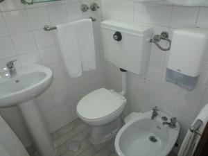 uma casa de banho branca com um WC e um lavatório em Pensão Residencial Luanda em Tomar