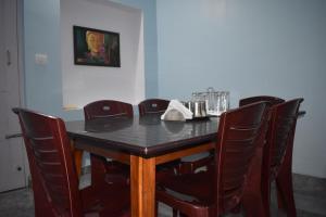 une table à manger et des chaises avec une table noire et des chaises dans l'établissement Srishti Homestay, à Madikeri