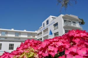 ein Gebäude mit rosa Blumen davor in der Unterkunft Apartamentos Marfina in Castelldefels