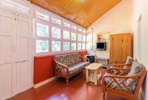 a living room with two chairs and a couch at Thanmaya Homestay in Chikmagalūr