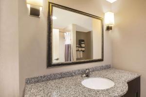 a bathroom with a sink and a mirror at La Quinta by Wyndham Baton Rouge Denham Springs in Baton Rouge